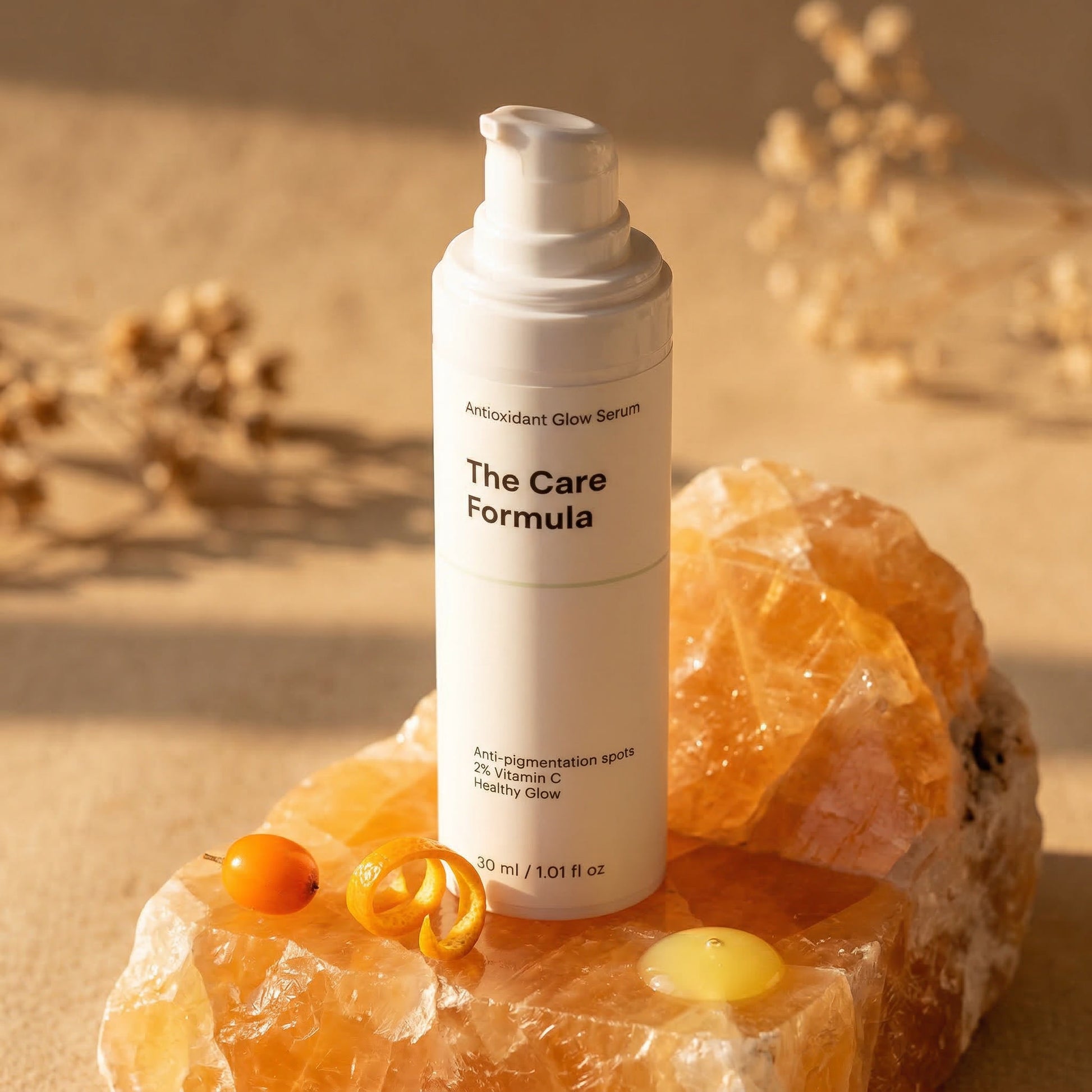 The Care Formula Antioxidant Glow Serum skincare serum bottle resting on a piece of raw orange calcite with sea buckthorn berry and mandarin zest