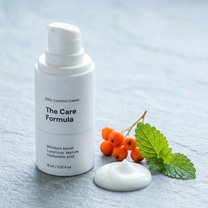 The Care Formula Daily Comfort Cream Skincare bottle with a smear of cream and berries on a light background