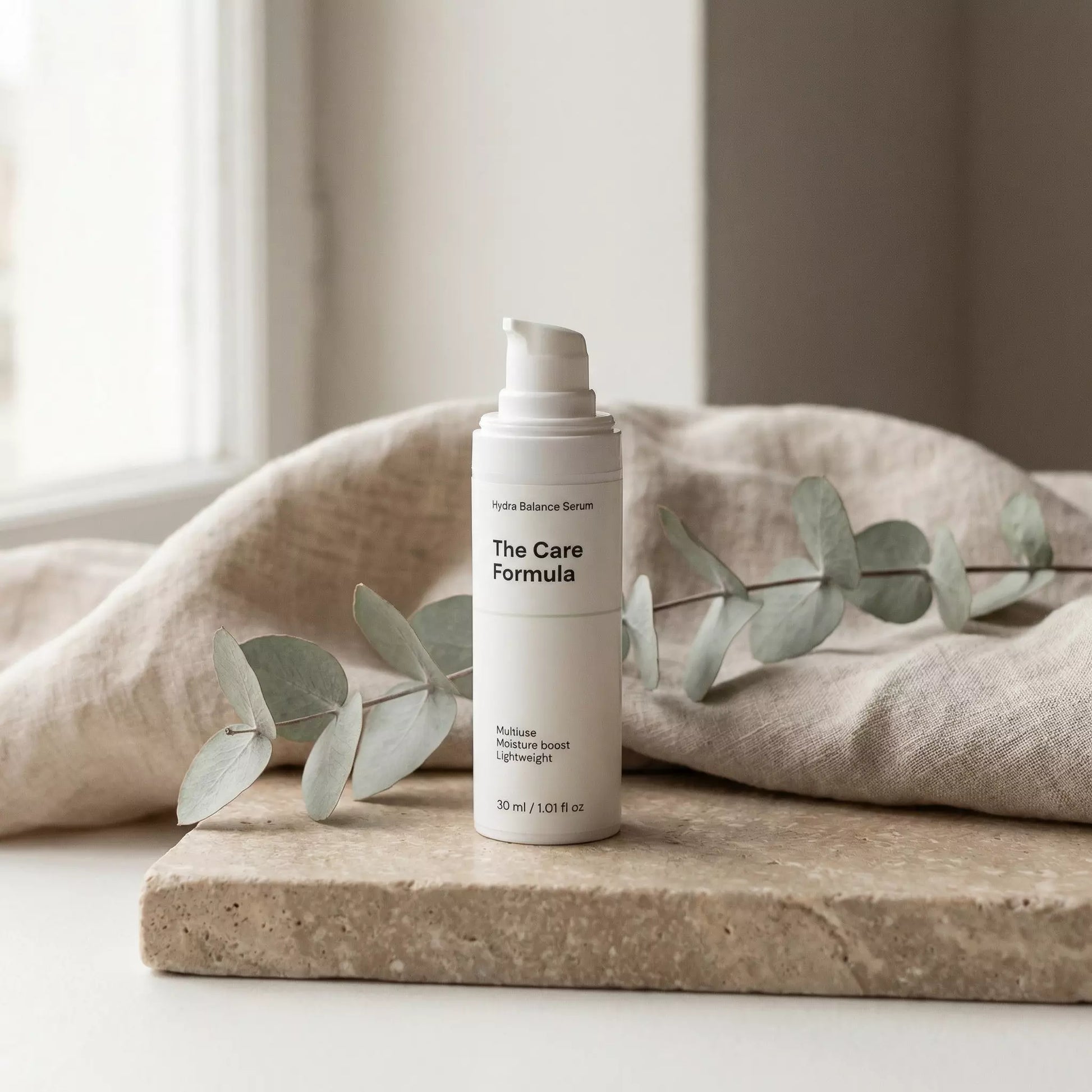 The Care Formula Hydra Balance Serum lightweight gel serum lifestyle scene on neutral stone surface