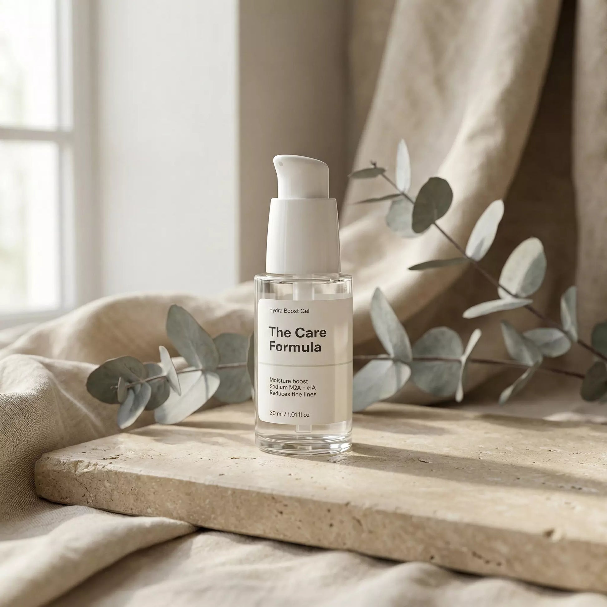 The Care Formula Hydra Boost Gel clear gel serum lifestyle scene with eucalyptus on neutral stone surface
