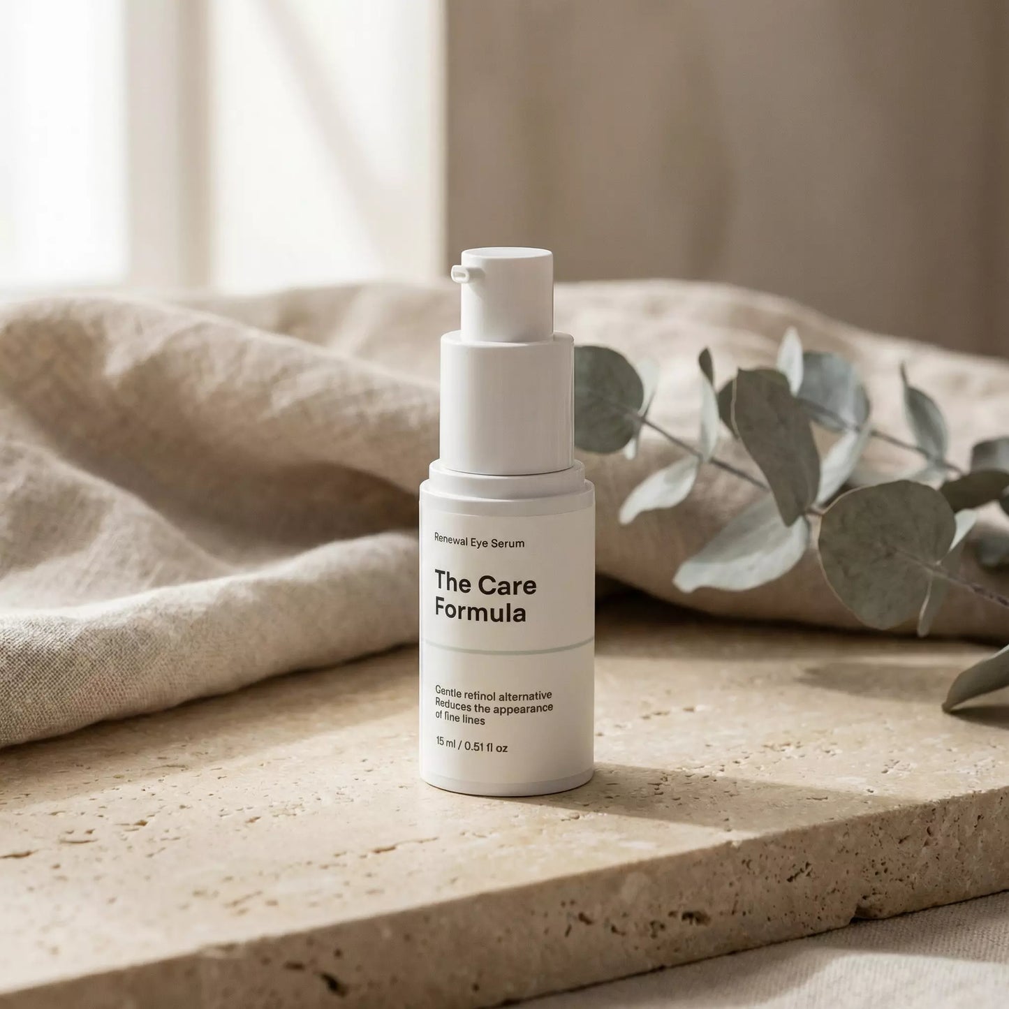 The Care Formula Renewal Eye Serum lifestyle scene on a natural stone surface with soft linen and eucalyptus