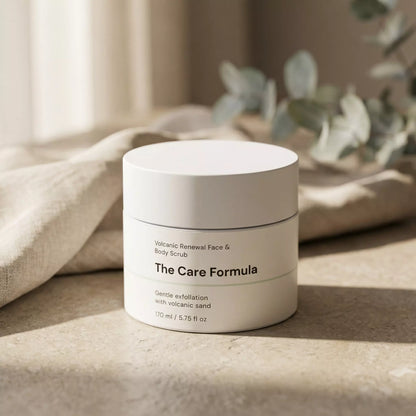 The Care Formula Volcanic Renewal Face and Body Scrub skincare exfoliating lifestyle scene on neutral stone surface